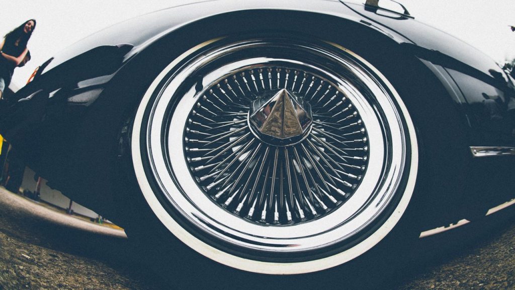 Detailed view of a classic car's chrome wheels showcasing luxury design and style.