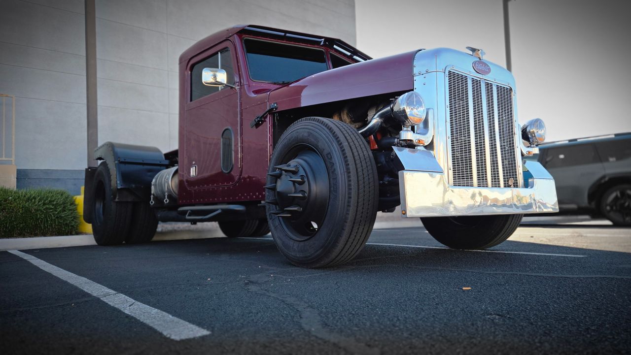 Classic red semi truck parked outdoors showcasing vintage design.